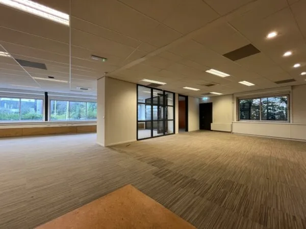 Leeg kantoorpand aan de 2e Daalsedijk met grote ramen, systeemplafond en glazen binnenwand.